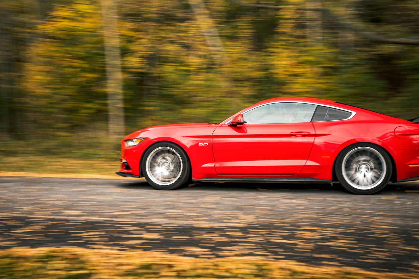 Red Ford Mustang panning shot at speed